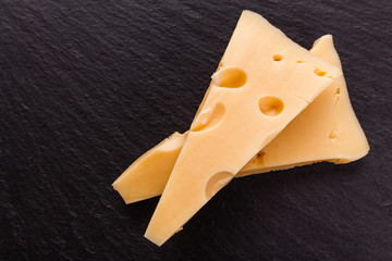 Piece and slices of cheese on a white background