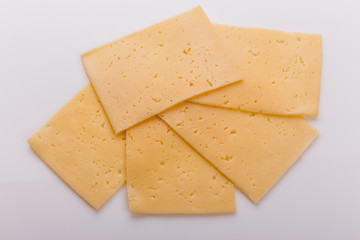 Piece and slices of cheese on a white background