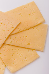 Piece and slices of cheese on a white background