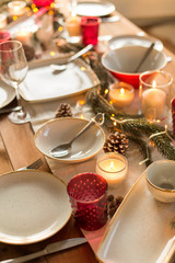 christmas, holidays and eating concept - table served and decorated for festive dinner at home