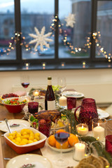 christmas dinner and eating concept - food and drinks on table at home