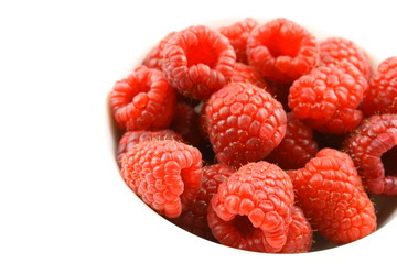 fresh red raspberry fruits in a small white bowl