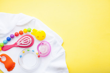Baby yellow booties. Children's shoes and toys on yellow background. Newborn.