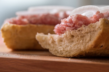 Schweinemett Brötchen mit Zwiebeln auf Holzbrett