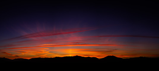Beautiful autumn sunset landscape with a lot of colors like red, purple, blue... and the mountains silhouettes. Autumn sunset. PC screen.