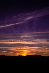 Beautiful autumn sunset landscape with a lot of colors like red, purple, orange, yellow, blue... and the mountains silhouettes