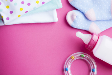 Baby yellow booties. Children's shoes and toys on pink background. Newborn.