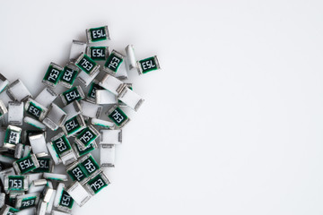 Scattered SMD Chip Resistor / Ceramic Capacitor and a glass bottle on white isolated background