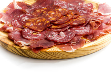 Typical spanish food with ham and sausage on a wooden plate