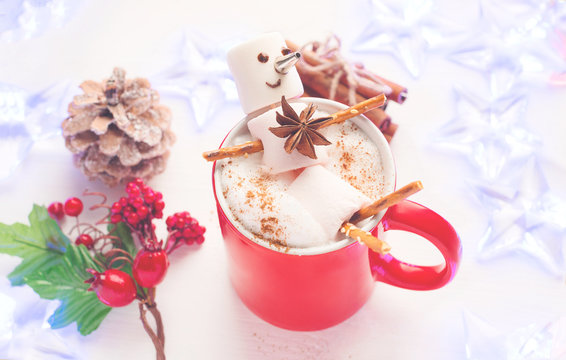 Funny marshmallow snowman in red cup of hot chocolate