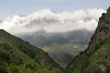Naklejka premium Mountain landscape, green peaks and clouds.