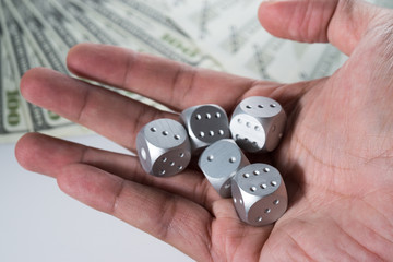 A conceptual Gambling image with Metal Dice and fake USD dollar notes on white isolated background