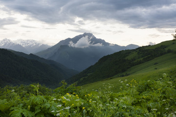 Mountain landscape, green peaks and clouds.