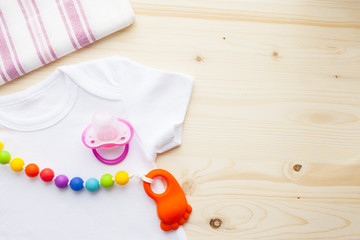 Baby yellow booties. Children's shoes and toys on white wooden boards background. Newborn.