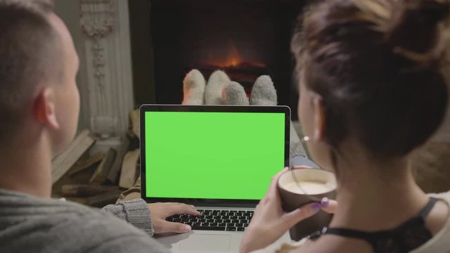 Young couple watching film on a laptop in a country house