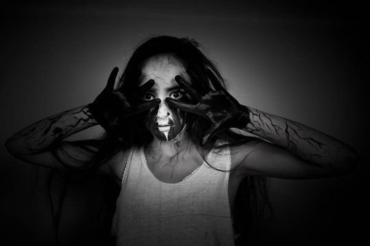 Halloween. Portrait mad girl with black hands and veins on her face. concept of halloween and day of the dead.