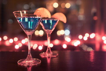 glasses of cocktails martini drinks on background of lights