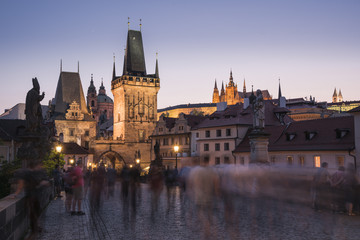 Charles Bridge, Lesser Towers, and Prague Castle at night with blurred pedestrians, Prague, Czech Republic