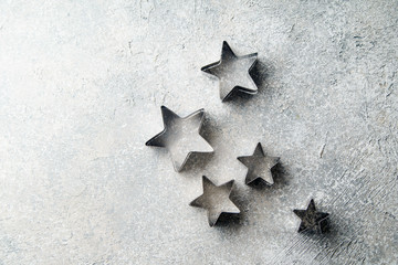 Forms for cutting cookies in star shape on rusitc textured background
