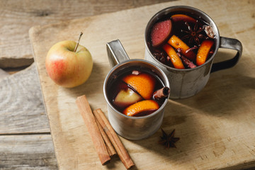 Mulled wine with apple, orange, cardamom, cinnamon, anise and honey. Served in metallic mugs. Wintertime mood.