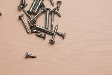 Self-tapping screw on a wooden background. 