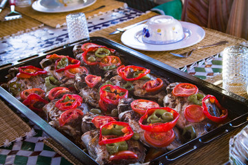 Black baking tray with baked dorado fish and sliced ​​fresh vegetables. Baking. Cooking cooking