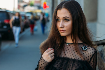 Emotional portrait of Fashion stylish portrait of pretty young woman. city portrait. sad girl. brunette in a black dress. expectation. dreams