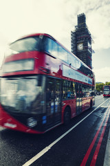 Fototapeta na wymiar Big Ben Under Conservation Works and Red double decker bus in motion on Westminster Bridge. London, England, United Kingdom