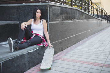 Beautiful woman with a skateboard on the street