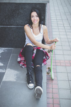 Beautiful woman with a skateboard on the street