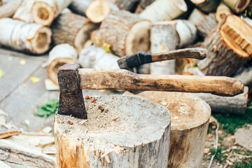 A sharp blade of an ax that sticks out in a wooden chock. rustic concept