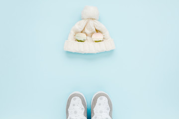 White women winter the boots and hat, glasses isolated on blue background. Flat lay, top view trendy fashion feminine background. Beauty blog concept. Fashion blog look. 