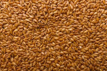seeds of golden flax on a dark stone background
