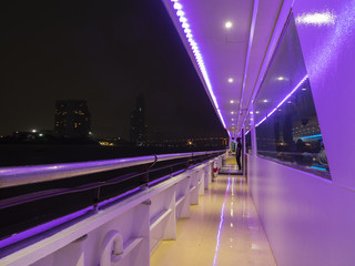 Fototapeta na wymiar The purple illumination on the boat with night view