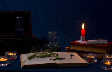 Magic potion, ancient books and candles on dark background. Fairy magic and Halloween.