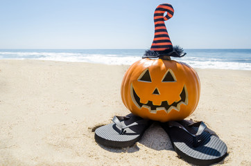 Beach Halloween background with pumpkin in the witch's hats