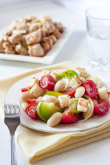 Salad with tomatoes, boiled white kidney beans and croutons from white bread