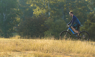 A cyclist rides the hills, Beautiful portrait of a guy on a blue bicycle	