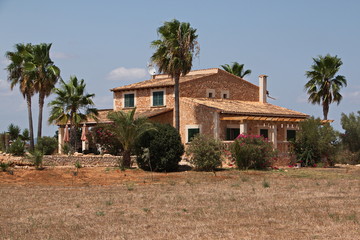 Fototapeta na wymiar Residential house with palm trees near Ses Salines on Mallorca 