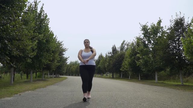 Fat girl is walking along the road