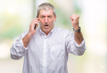 Handsome senior man talking on smartphone over isolated background annoyed and frustrated shouting with anger, crazy and yelling with raised hand, anger concept