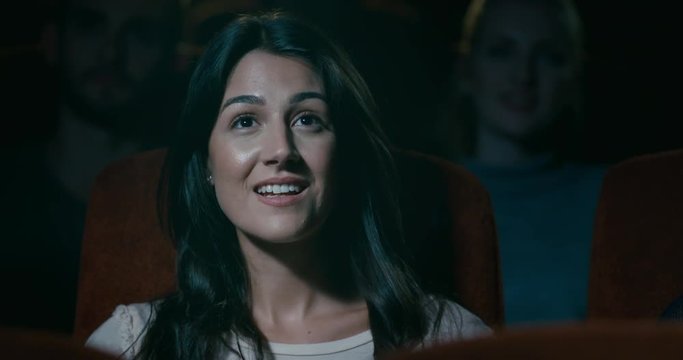 Movie theatre audience - A woman sitting, captivated by the movie