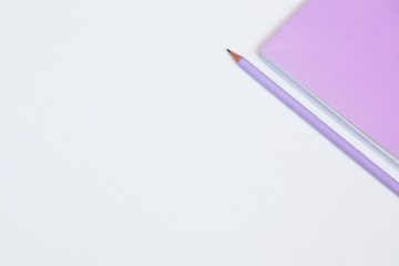 Fototapeta premium Pink notebook and pencil on white background. Selective focus