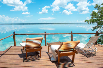 Fototapeta na wymiar Camastros frente a laguna de 7 colores en Bacalar, Quintana Roo, México.