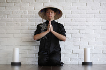 Asian young novice on a white brick wall