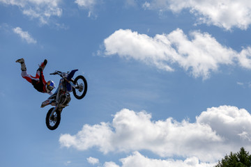 Fototapeta na wymiar Sports, extreme, speed, adrenaline concept. Stylish biker jumping on his motorcycle and flying in the sky among the clouds.
