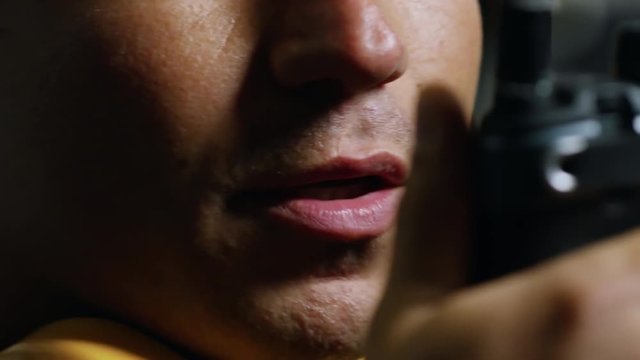 Extreme close up shot of unrecognizable male factory worker communicating with colleagues using two way radio, tracking right