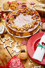 old wooden table with delicious Christmas cake decorations and different cookies