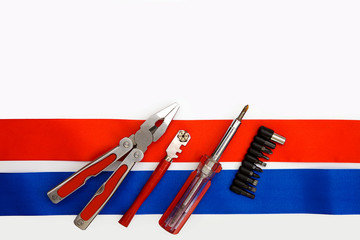 Pliers screwdriver metal pliers screwdriver cutter flag red blue white ribbon bow postcard background labor Dutch