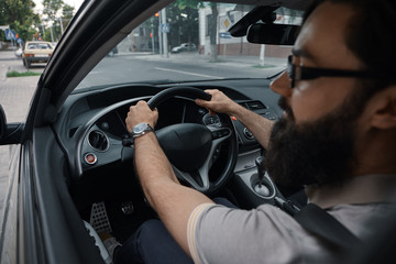 Fototapeta na wymiar Modern casual bearded man driving a car
